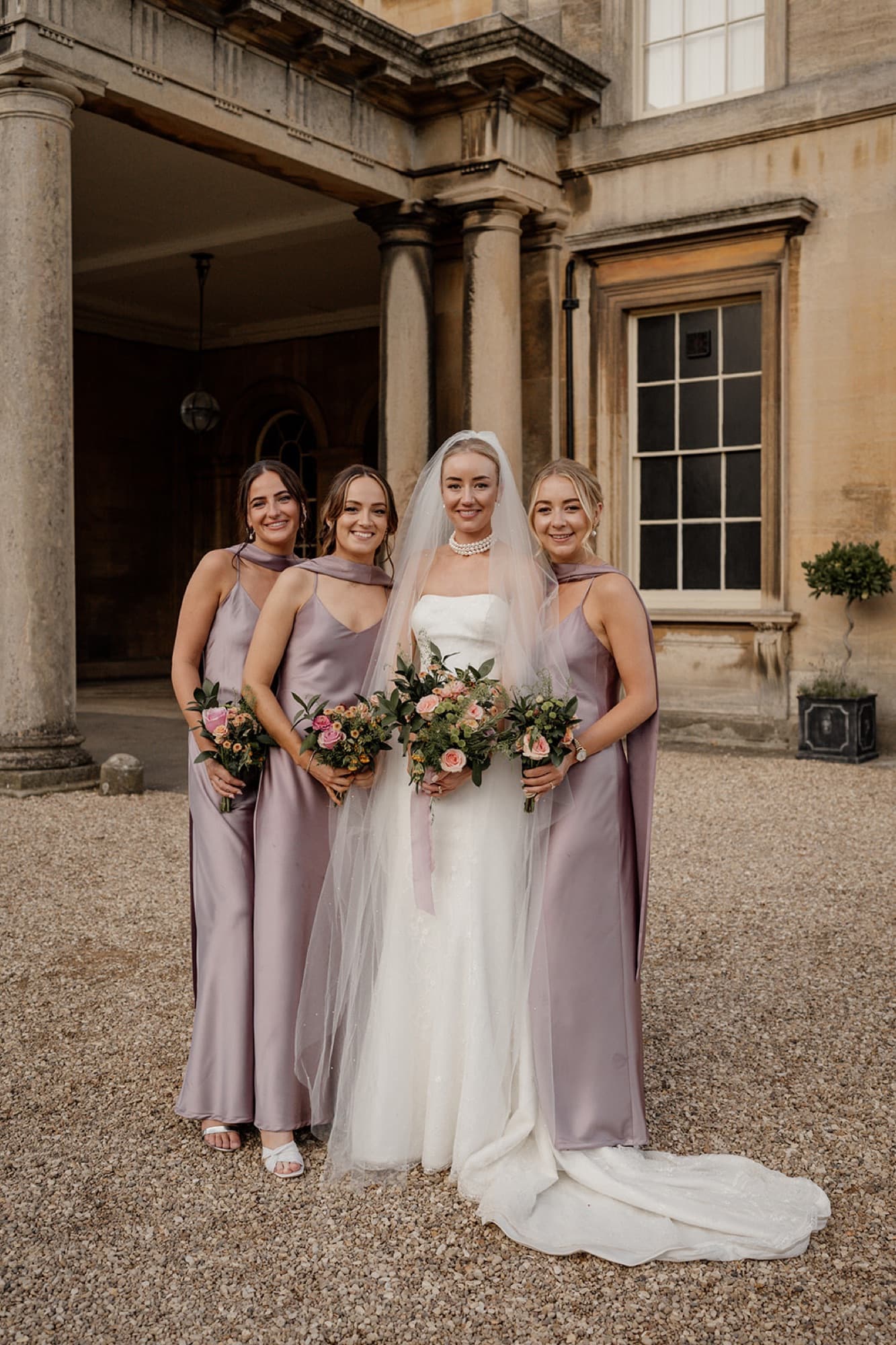 Bride with bridesmaids in dusty mauve, country house wedding