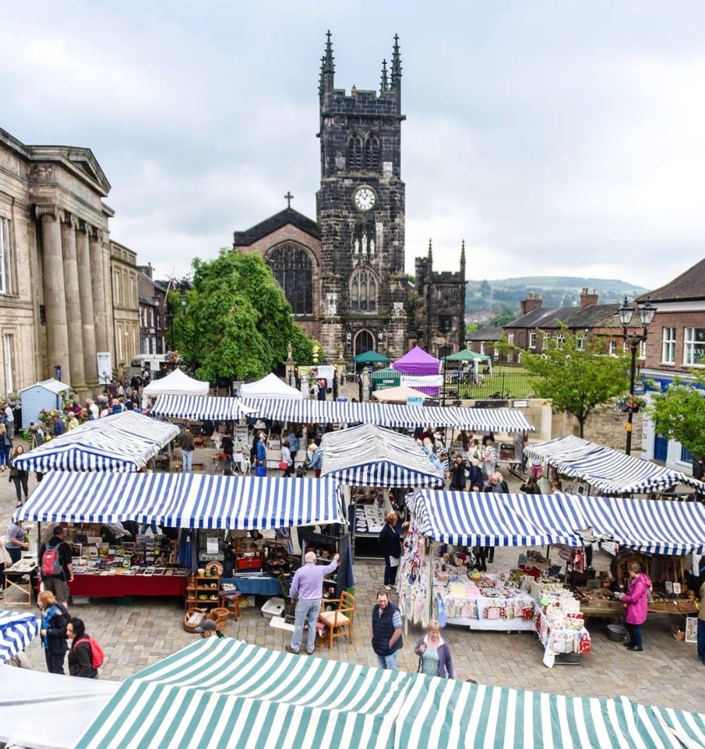 The blue and white striped market in Macclesfield town centre with the church behind.
