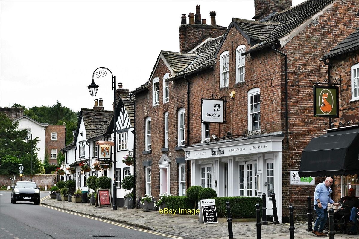 The main road through Prestbury village, with Bacchus and the row of historic buildings in view.